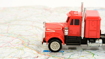 transportation and travel concept - truck on the map