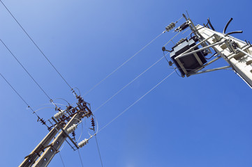 Two concrete electric poles and a transformer