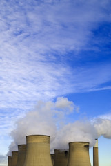 Cooling towers under blue sky with clouds
