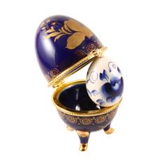 Dark blue easter egg in a gold small box on a white background