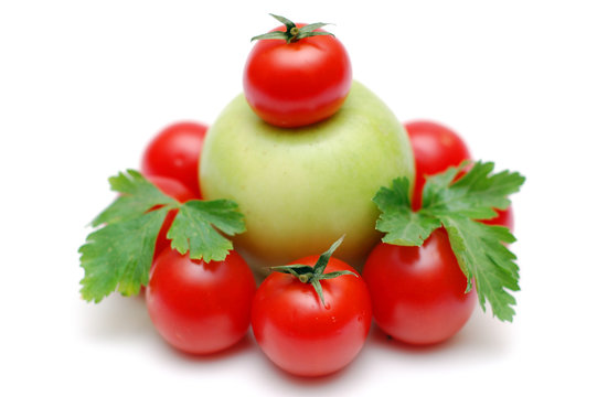 Green apple encircled by tomatoes decorated by parsley