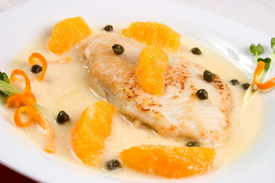 Closeup of grilled skate (ray) with orange and caper sauce