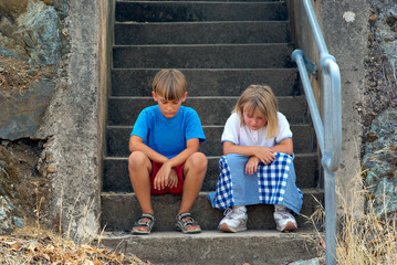 brother and sister sit on the steps