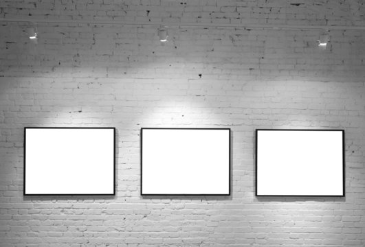 three frames on brick white wall