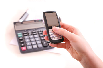 Cell phone in the female hand under the desk