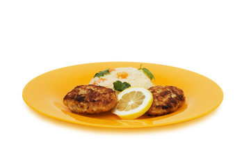Cutlets, rice and lemon on the plate isolated