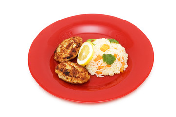 Cutlets, rice and lemon on the plate isolated