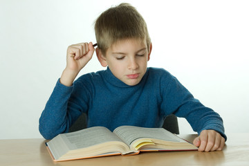 little boy read book and scratch one's head