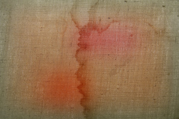Obraz premium Background from a rough dirty fabric with red spots