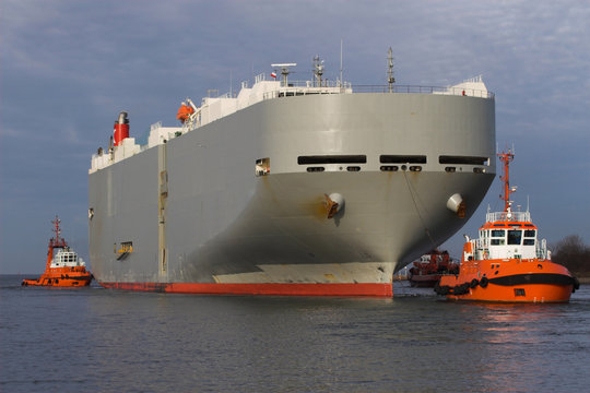 Big ship leave port of Gdansk with tug assistance