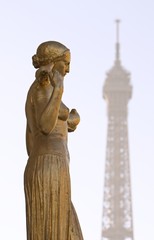 Fototapeta na wymiar Posąg na pierwszym planie z wieży Eiffla w Paryżu