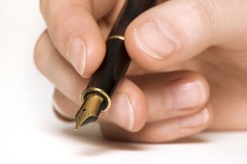 close up of a hand holding a pen. sharpness on pen.