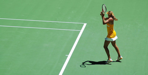 Fototapeta na wymiar dziewczyny w akcji tenisowy. ¯ółta sukienka i zielone pola do tenisa