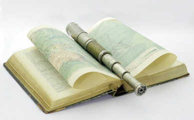 Old telescope and old book with map