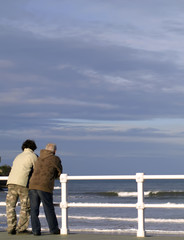 Joven y anciano mirando al mar