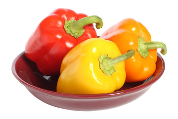 Red, yellow and orange bell peppers on plate