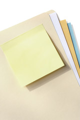 Blank yellow sticky note on a manila folder.  
