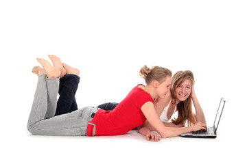Fototapeta na wymiar Girls lying on floor using laptop
