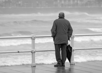 Hombre con paraguas mirando al mar