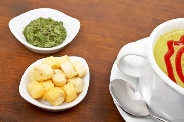 Spinach puree and croutons  on wood background. Shallow DOF