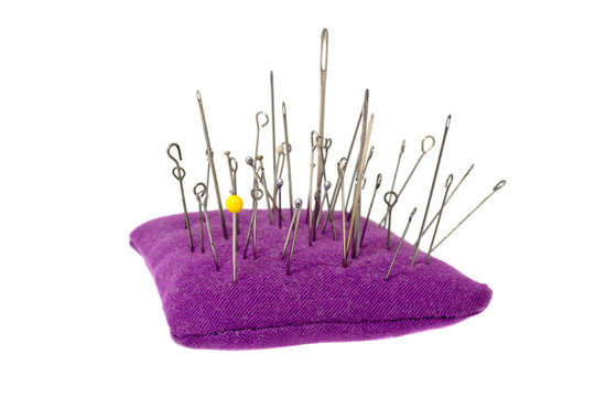pincushion with lot of needles and pins for sewing isolated