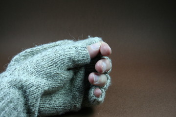 Hand mit Fingerhandschuh aus grauer Wolle