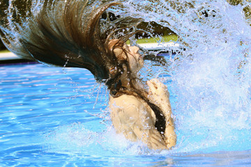 woman swinging with her hair in the swimming pool