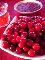 Fresh cherry in bowl, raspberry cooking and beverage on table