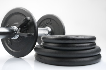 Obraz na płótnie Canvas Stack of black weights on a white background. Horizontal shot.
