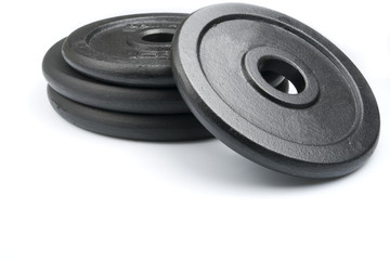 Stack of black weights on a white background. Horizontal shot.