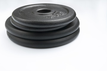 Stack of black weights on a white background. Horizontal shot.