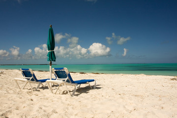 Fototapeta na wymiar two sun beds with umbrella on a tropical beach