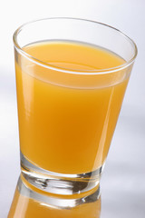 Orange juice on glass, reflecting background