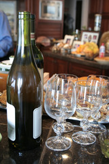 Wine bottles with glasses and food on counter in kitchen