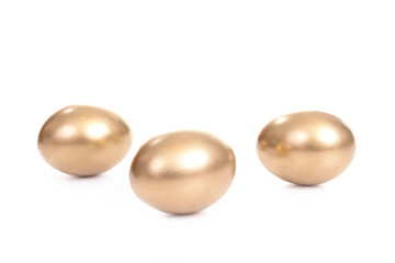 Three golden eggs isolated on white background
