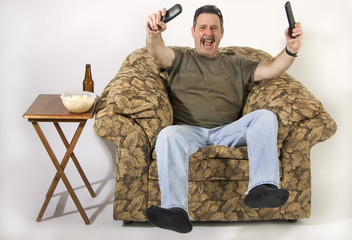 Sports fan on overstuff chair watching TV