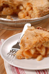 A slice of a deep dish apple pie with a flaky crust