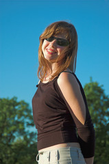 The young beautiful smiling girl in sunglasses