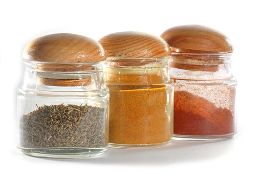 Jars with spices isolated against white background