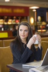 pretty woman in a cafe with a cup of tea and laptop focus  cup
