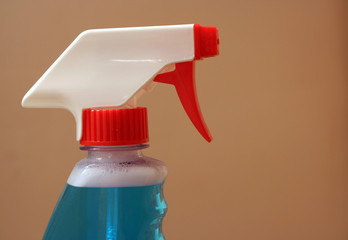 Spray bottle on beige background