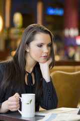 young business woman taking a cup of tea sitting in a bar