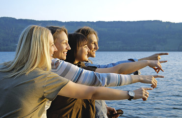 Four girls having fun beside a lake.