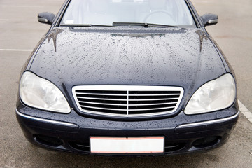 Obraz na płótnie Canvas Modern expensive car with drops on a hood.