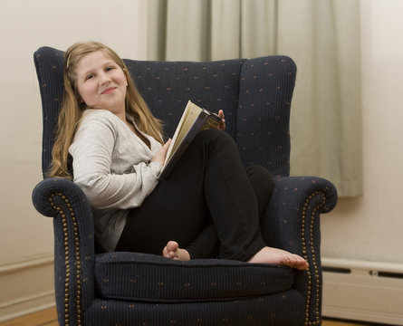 A young girl curling up with a good book