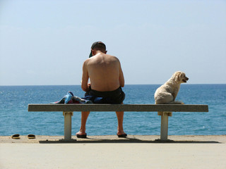man with a dog on quay of the mediterranean sea