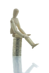 Manikin sitting on top of coins pile doing nothing