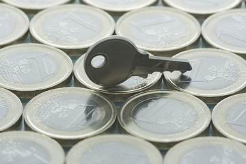 Euro coins pattern and key standing on top