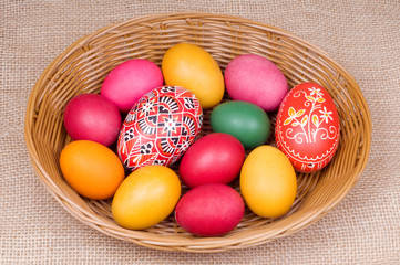 Fototapeta na wymiar Colorful Easter eggs in straw basket on bagging