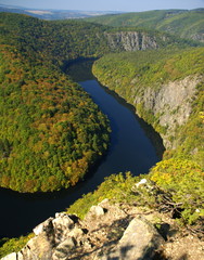 Bohemian river makes turn in a autumn forest landscape